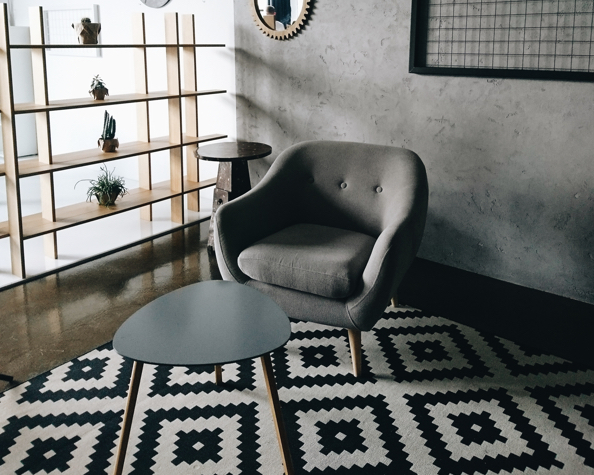 A decorative chair and table set, inside of a modernly furnished room